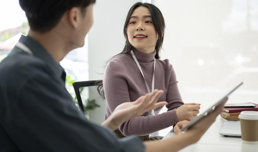 Regional center team member offering a consultation to an EB5 investor in a modern office setting, discussing Green Card options and investment strategies.
