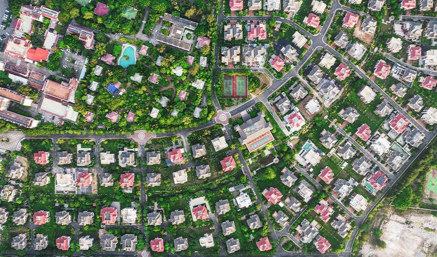 Aerial view of a residential community with homes, greenery, and amenities, symbolizing EB5 real estate development projects.