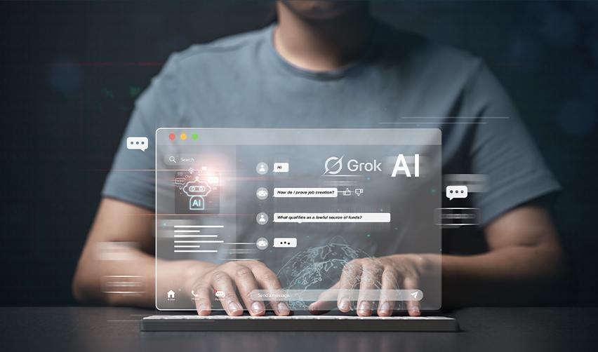 Person typing on a laptop with a virtual Grok AI chat interface displayed, showing EB5 investors asking questions about job creation and lawful source of funds.