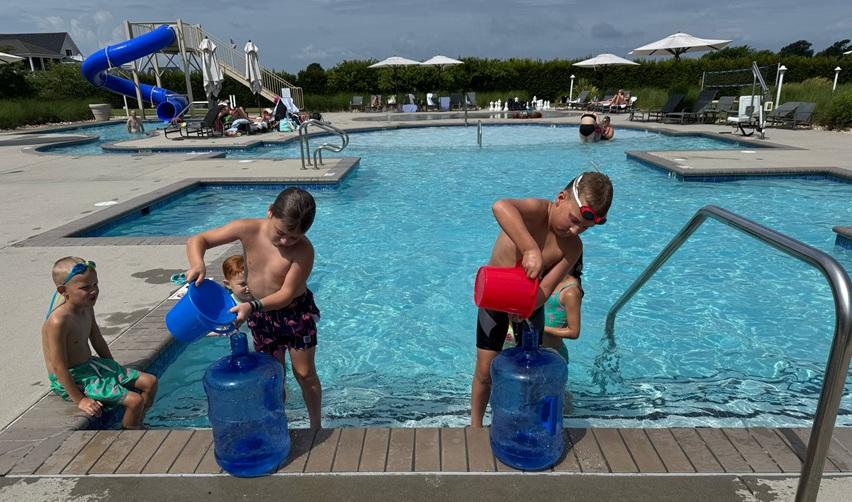 Children enjoying poolside games at Bay Creek’s Life Center, highlighting family-friendly amenities that strengthen residential appeal and EB5 investor confidence.