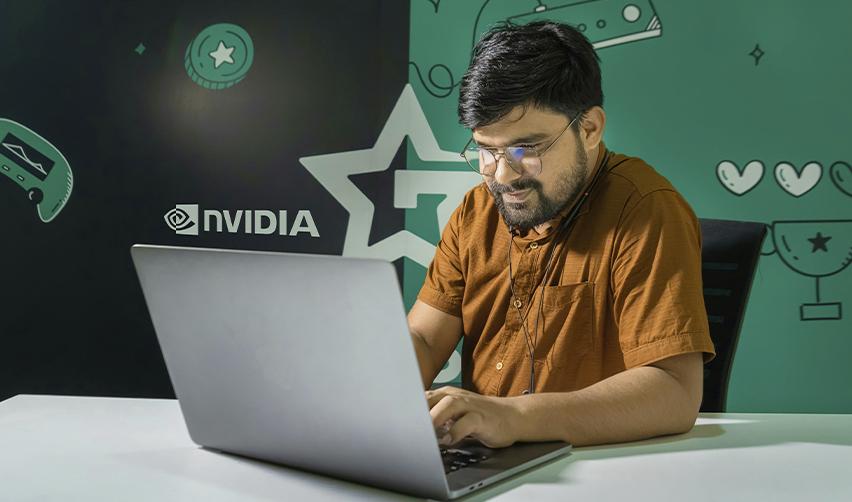 Indian EB5 professional working on a laptop at NVIDIA office, symbolizing H1B employees exploring EB5 investment options for U.S. residency.