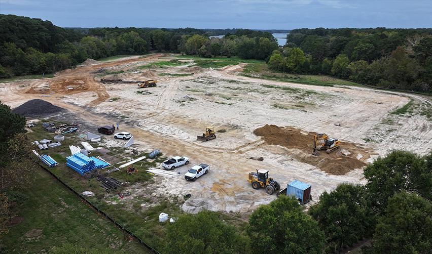 A construction site with vehicles and trees