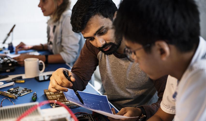 Team of engineers reviewing circuit diagrams at a tech workspace, representing NVIDIA H1B employees considering EB5 as an alternative path to stability.