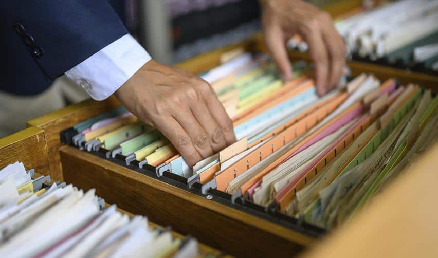Professional reviewing EB5 case files and records in a filing cabinet, representing documentation, due diligence, and USCIS review process.