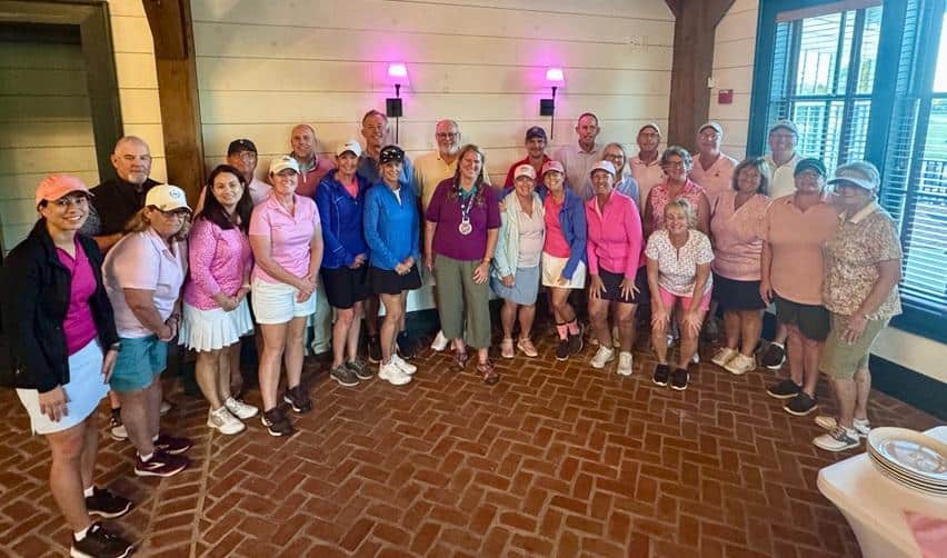 Bay Creek golfers and residents wearing shades of pink gather for a group photo after the Pink Ball Tournament, celebrating camaraderie and community spirit in support of breast-cancer awareness.