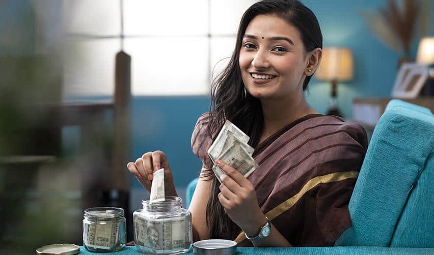 Investor smiling while managing savings and counting cash at home, reflecting EB5 applicants preparing investment funds and financial documentation.