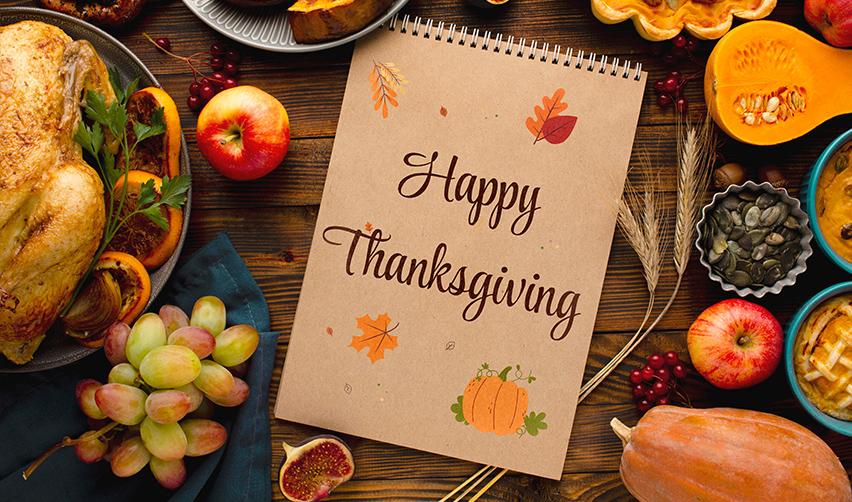 Thanksgiving table with turkey, seasonal fruits, and a notepad reading Happy Thanksgiving, representing a moment of reflection for EB5 investors planning their future in the United States.