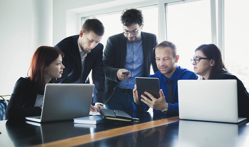 A team of EB5 professionals reviewing project documents around a conference table, symbolizing due diligence and investor evaluation of urban and rural projects.