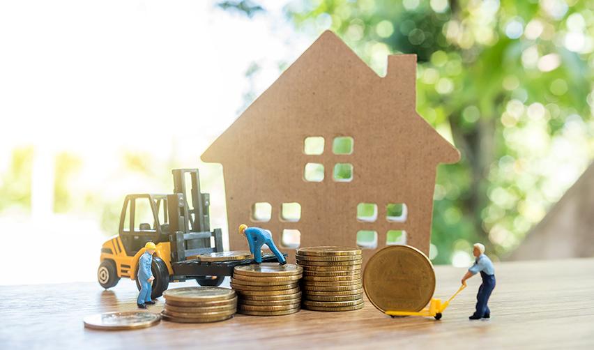 A miniature people working on a stack of coins