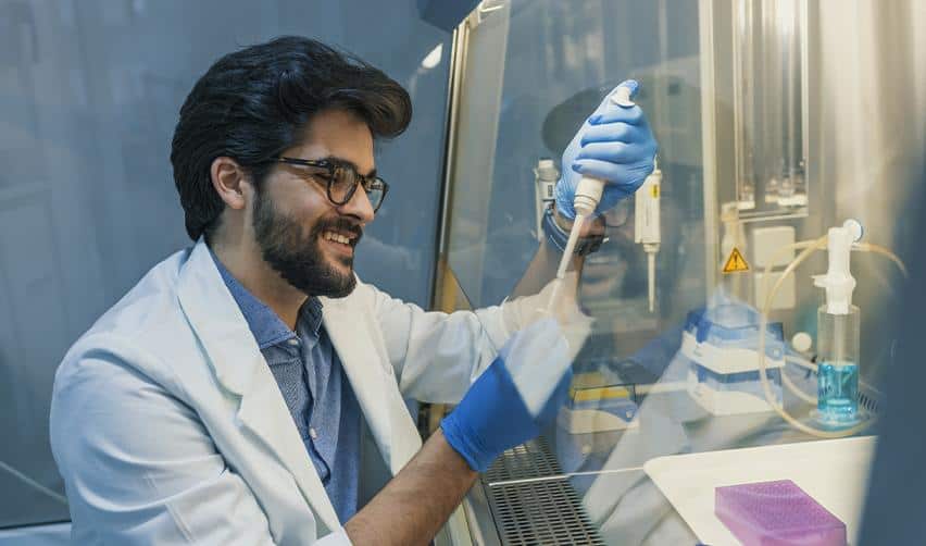 Smiling researcher working in a modern laboratory, symbolizing the career freedom and professional opportunities available to EB5 investors with work authorization in the United States.
