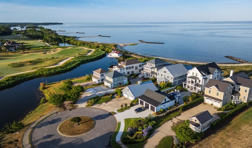 Aerial view of Bay Creek’s coastal homes and golf course along the Chesapeake Bay, showcasing the community’s scenic setting and luxury design.