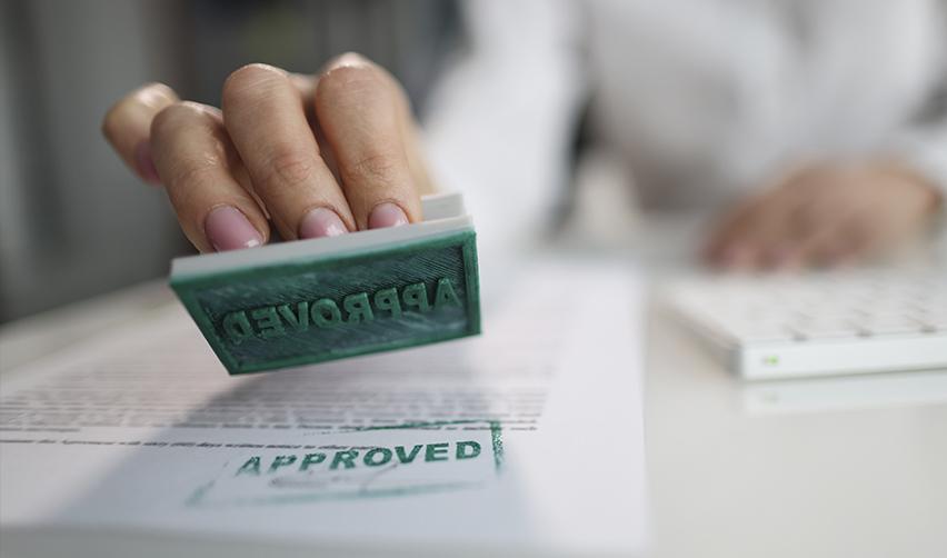 Close-up of an approval stamp marking a document, representing successful EB5 visa outcomes following careful data analysis and professional guidance by EB5AN.