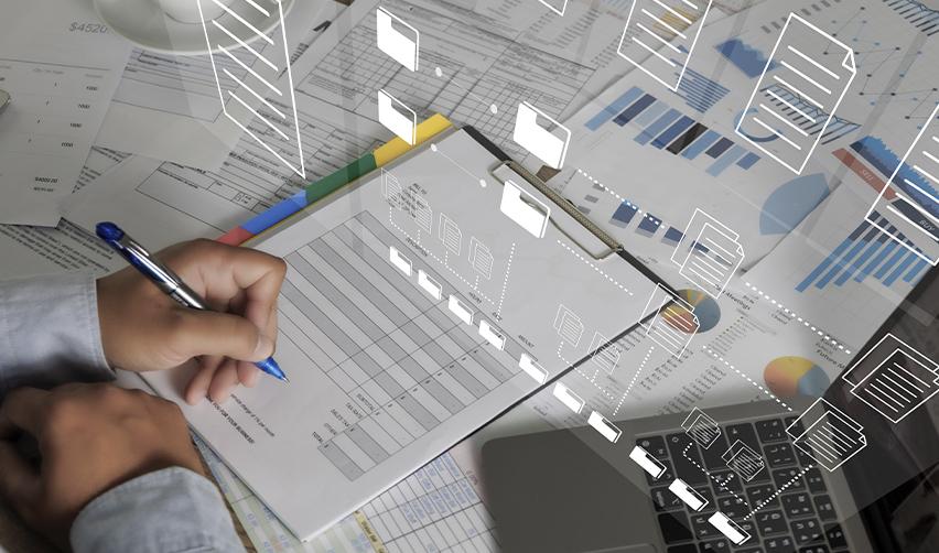 Hands reviewing financial documents and digital folders on a laptop, depicting AI-driven document analysis and data organization in EB5 due diligence.