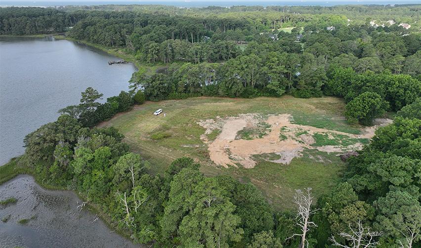 Expansive waterfront land section at Bay Creek surrounded by mature trees and wetlands, prepared for future EB5 residential development.