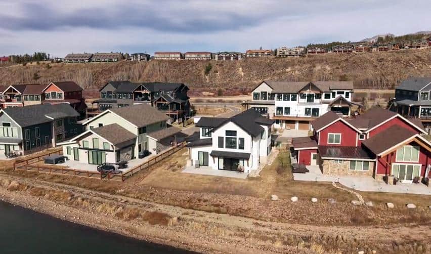 Completed homes along the waterfront at Grand Park, showcasing modern mountain architecture and an established residential neighborhood within the community.