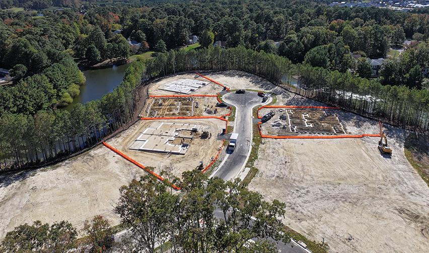 Active construction site with new foundations outlined in orange safety barriers at Bay Creek, capturing progress in the community’s latest residential phase.