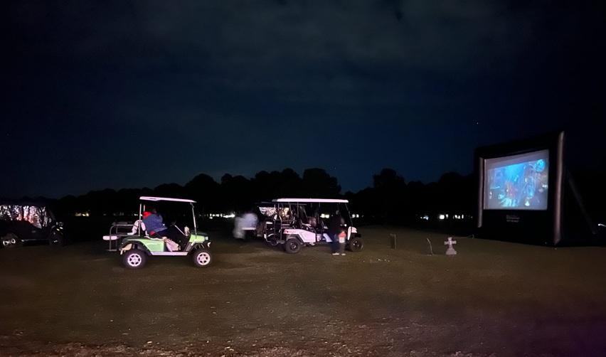 Golf carts gathered under the night sky for Bay Creek’s Halloween Drive-In Movie showing The Haunted Mansion.