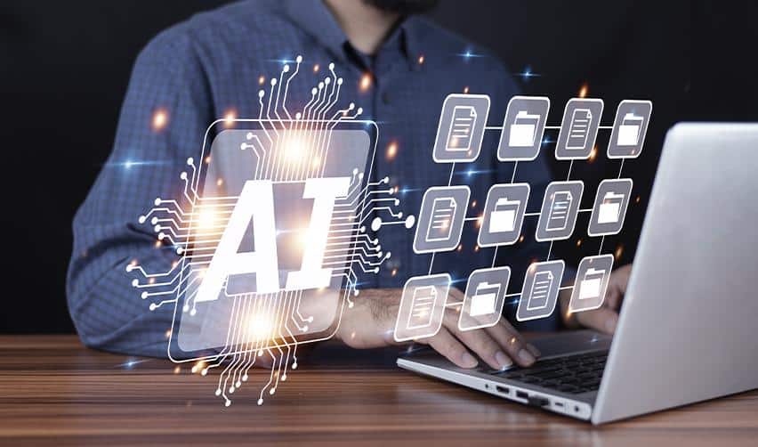 A person working on a laptop with digital AI icons and file graphics, representing AI automation in managing EB5 investor records and reporting systems.