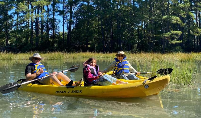 Families kayaking through Old Plantation Creek during Bay Creek’s Kayak Experience, enjoying the calm waters and fall scenery.