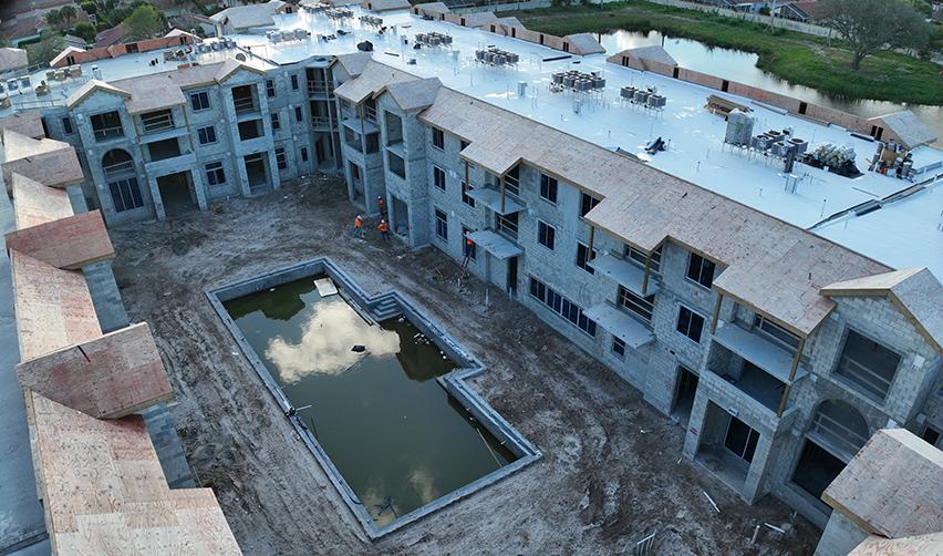 Aerial view of Boynton Beach Multifamily under construction, showing completed roofing, installed windows, and courtyard areas as vertical construction advances on this urban EB5 project.