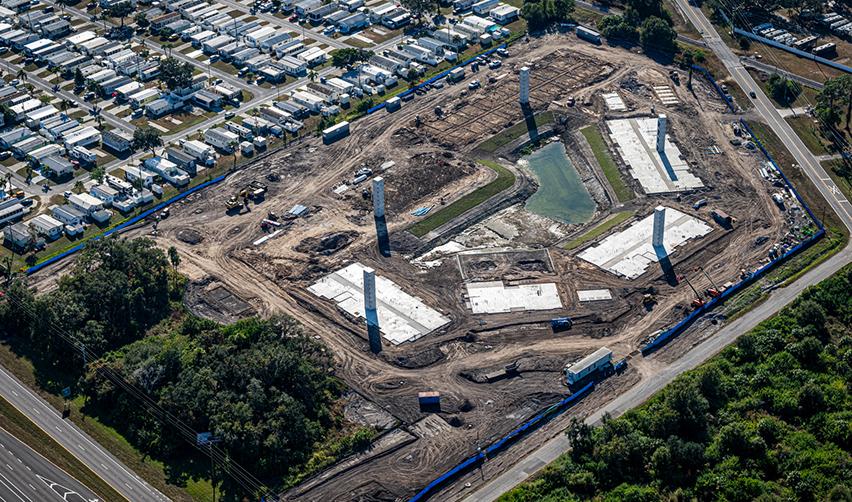 Aerial view of Terra Ceia Multifamily construction site in Palmetto, Florida, showing completed building slabs, vertical concrete columns, and active earthwork, illustrating early-stage progress of the EB5 multifamily development.