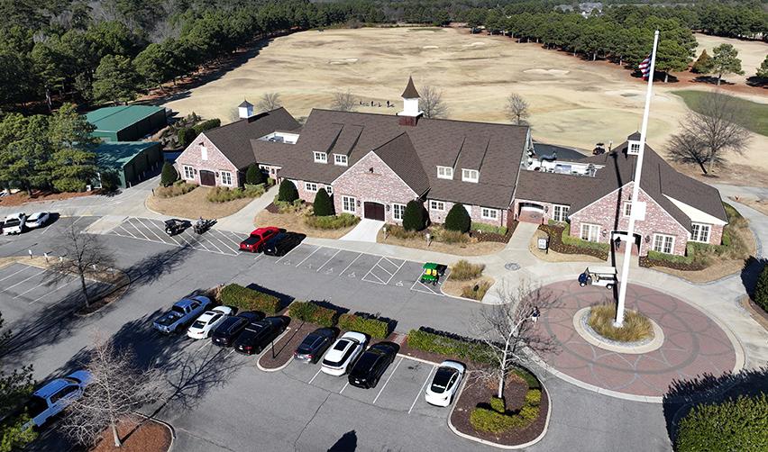 Overhead view of the Bay Creek golf clubhouse and surrounding course, with parking and amenities visible, highlighting completed recreational infrastructure that supports community growth and EB5 job creation.