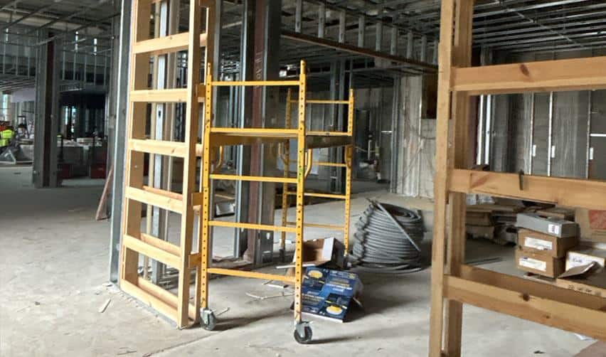 Interior construction at Boynton Beach Multifamily showing metal framing, mechanical and electrical rough-ins, and ongoing drywall preparation contributing to EB5 eligible job creation.