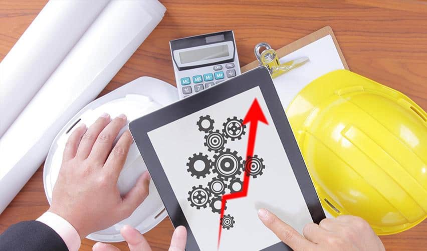 A tablet displaying interconnected gears and an upward arrow next to construction helmets and planning tools, representing clear project structure, transparency, and sustainable growth in traditional rural EB5 investments.