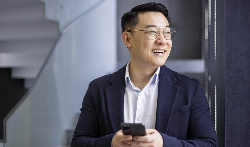 A professional investor checking updates on a smartphone, representing EB5 investors using digital tools for real-time USCIS case tracking and immigration status monitoring.
