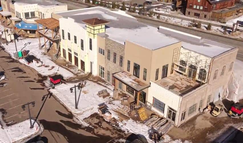 Aerial image of nearly enclosed mixed-use buildings at Grand Park, with roofing completed, exterior finishes underway, and construction equipment staged on-site as part of ongoing EB5-eligible development activity.