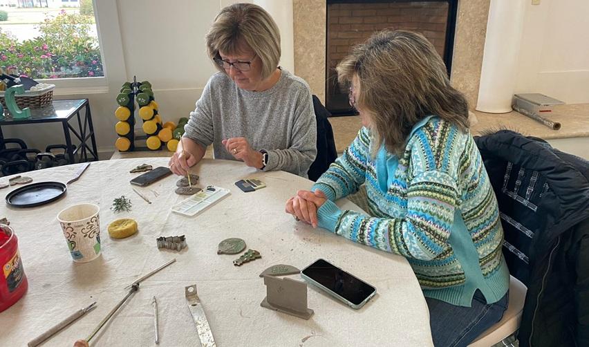 Bay Creek residents participating in a hands-on ceramic workshop at the Life Center, shaping and decorating clay pieces.