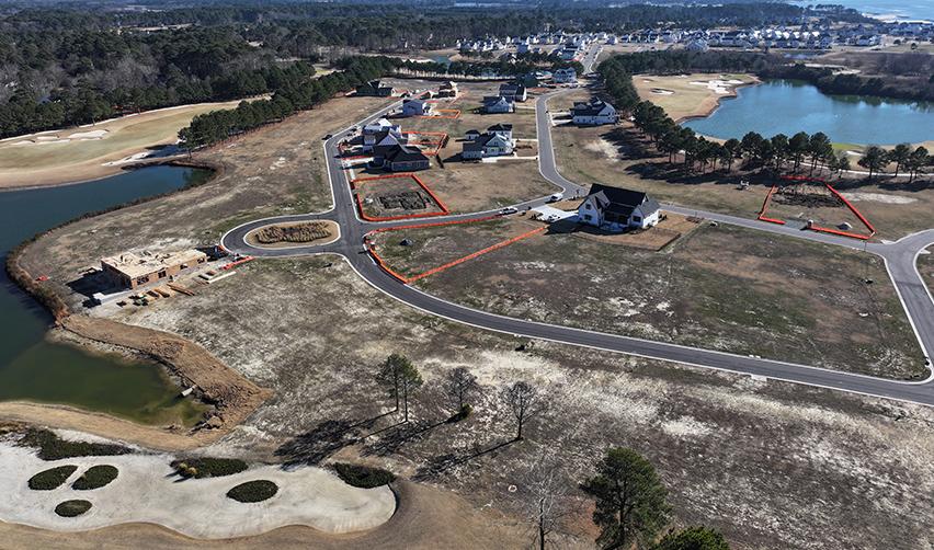 Aerial perspective of Bay Creek residential lots outlined for development, with paved roads, waterfront features, and nearby golf course terrain supporting long-term EB5 job creation.