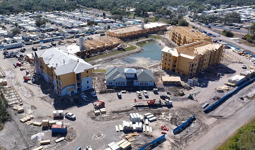 Aerial view of Terra Ceia Multifamily showing multiple apartment buildings under active EB5 construction around a central retention pond.