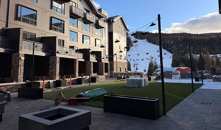 Courtyard area at Kindred Resort at Keystone with ski slopes visible in the background, showing outdoor common spaces taking shape as part of a four-season rural EB5 resort project.
