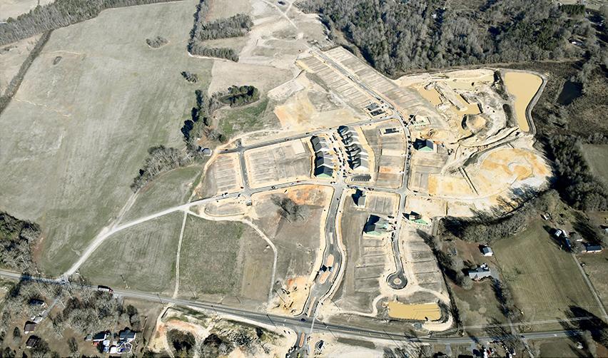 Aerial view of advanced infrastructure and defined residential lots at the Rocky River EB5 project, with visible roads, prepared home sites, and ongoing construction progress.