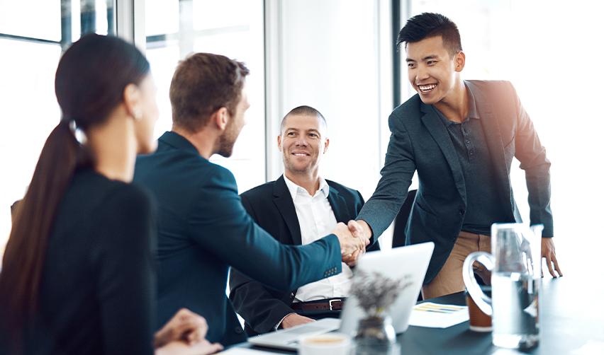 A group of professionals shaking hands during a business meeting, symbolizing EB5 investors working with advisors to plan a U.S. Green Card strategy.