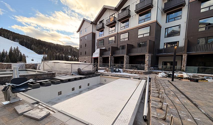 Central courtyard and pool deck at Kindred Resort at Keystone approaching completion, illustrating shared amenities designed to support year-round demand for a rural EB5 resort.