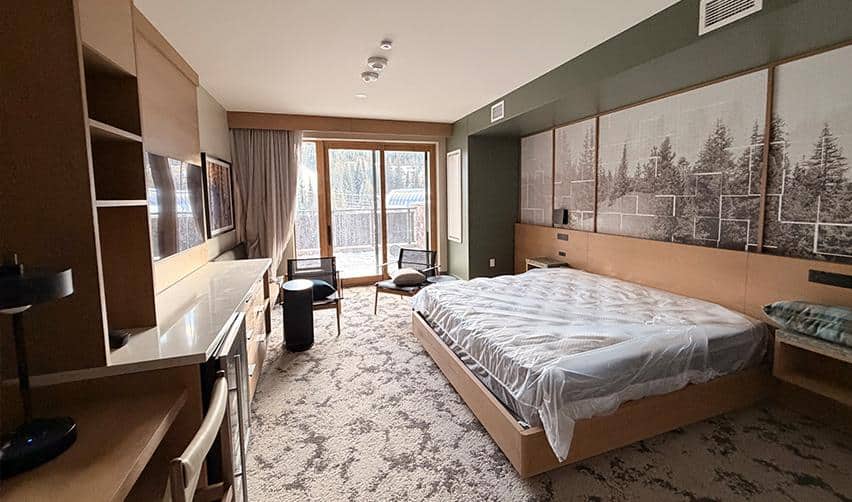 Guest room interior at Kindred Resort at Keystone with mountain-view balcony, highlighting completed accommodations designed for ski-season and year-round EB5 resort guests.
