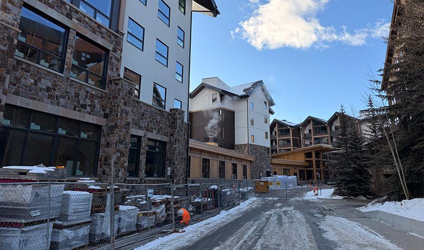 Exterior view of Kindred Resort at Keystone nearing completion, showing stone and wood finishes during winter construction as part of a rural EB5 ski-in mountain resort development.