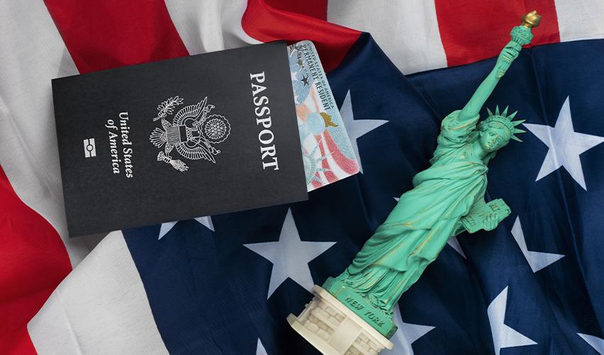 An American passport, EB5 green card and U.S. flag, representing permanent residence in the U.S. by investment.