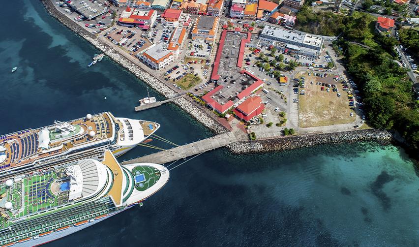 Aerial view of Caribbean port with cruise ships and coastal town, illustrating citizenship by investment destinations and island economies.
