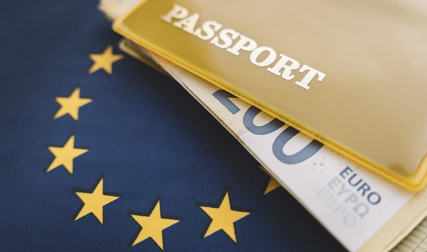 European Union flag with euro banknotes and passport, representing Golden Visa programs and residency by investment in Europe.
