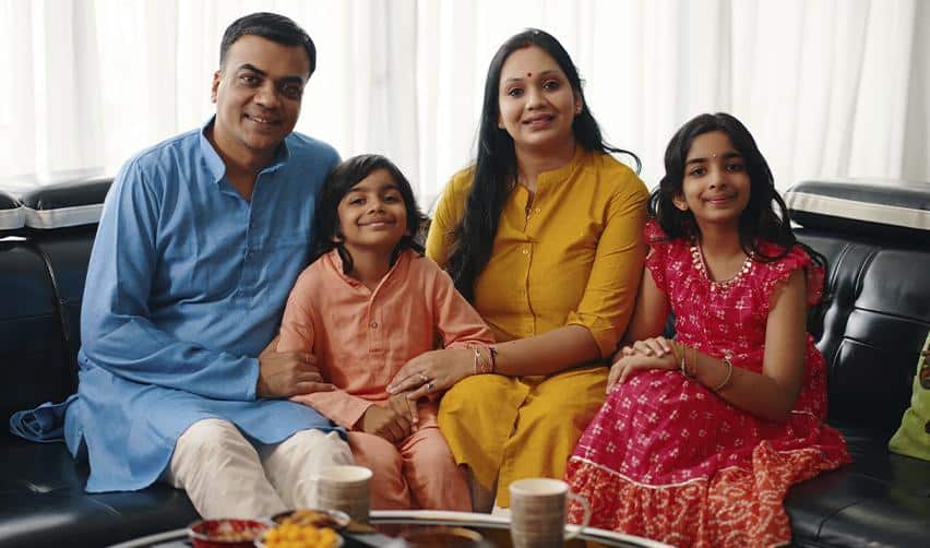 A happy Indian family of EB5 investors smiling at the camera.